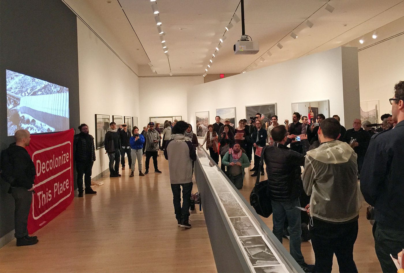 Protesters unfurled a banner in the gallery at the start of the action. (photo Hrag Vartanian/Hyperallergic)