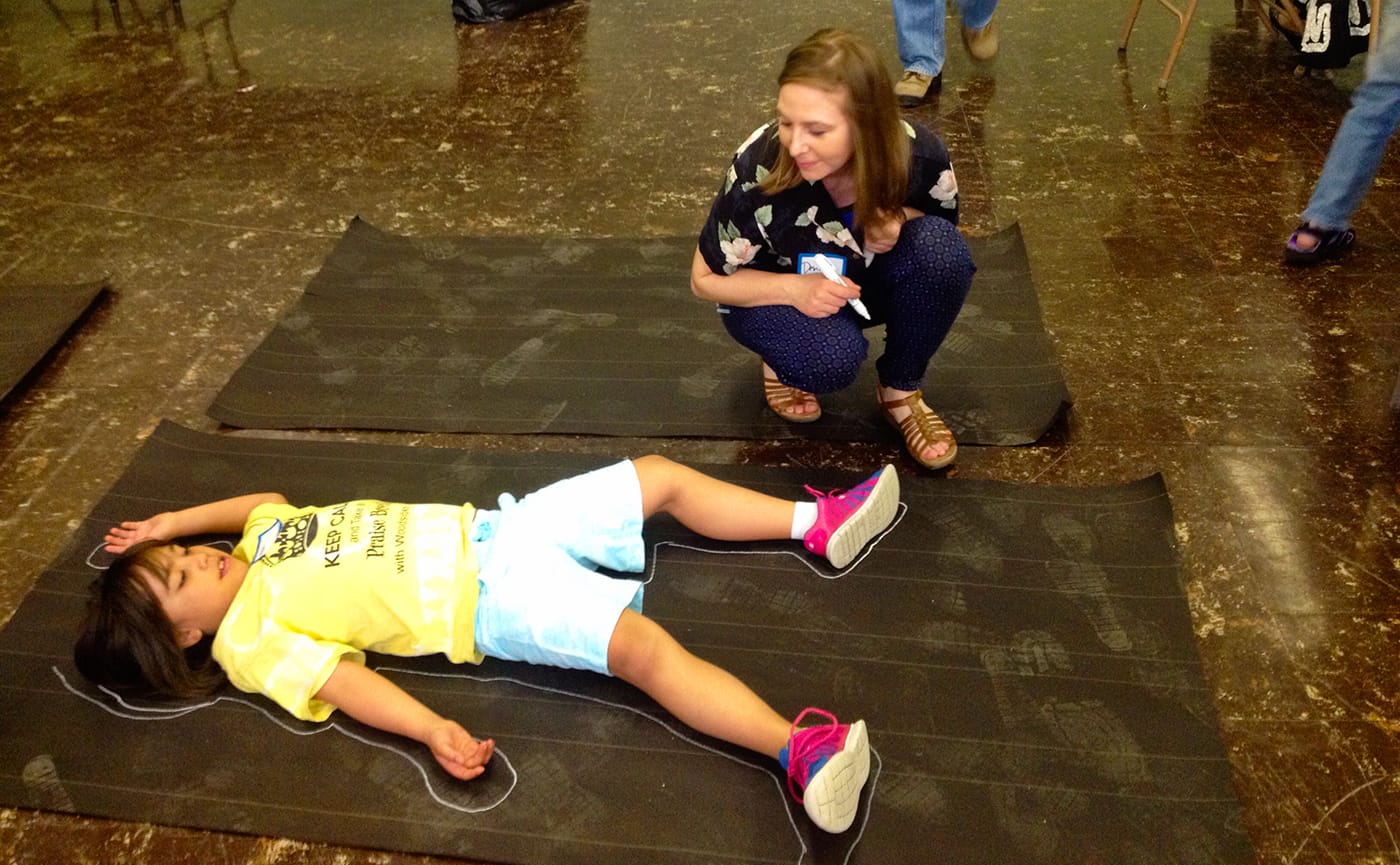 Flint artist/activist Desiree Duell with young Netiva Wilder in a 2015 performance that’s part of her project 'A Body of Water,' which Duell conceived of as a chance for Flint residents, especially parents and children, to grieve the ordinary pleasures and security taken from them by the toxins in their tap water. (photo courtesy Desiree Duell)