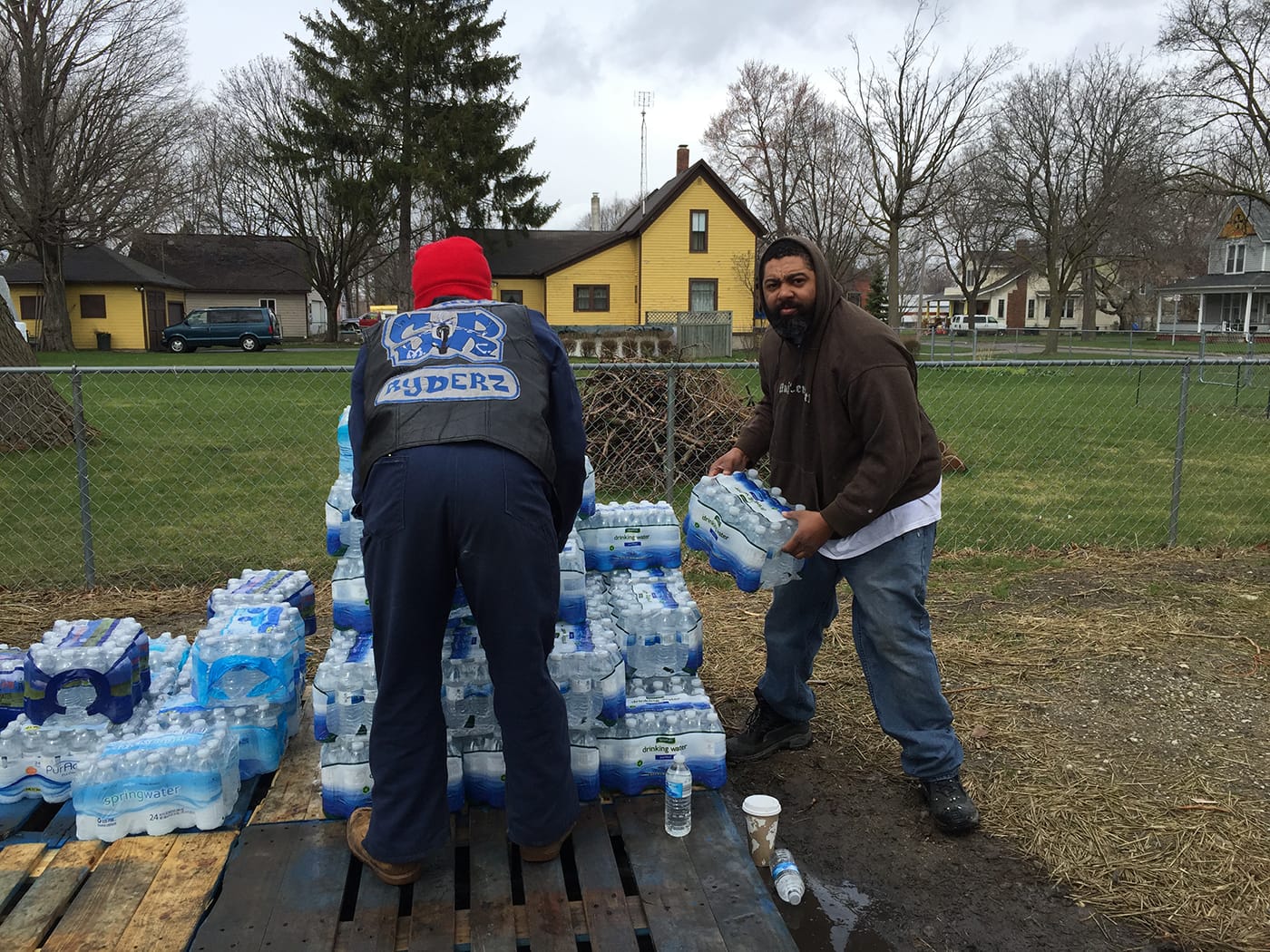 Marine Corps veteran George Grundy and an assistant move cases of water to be given to residents of Flint’s Carriage Town neighborhood. A hip-hop promoter, Grundy wants to organize a benefit for Flint residents hardest hit by the water crisis. 