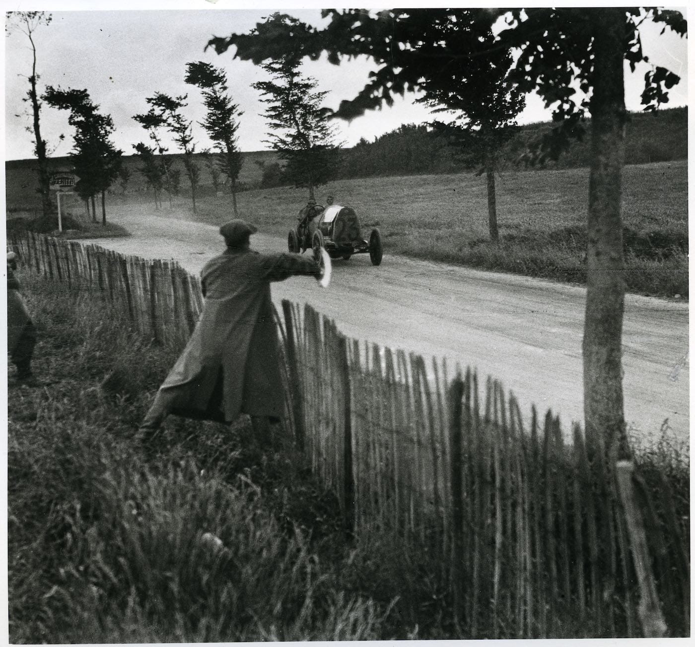 Jacques Henri Lartigue, "Grand Prix of the A.C.F. The great racing driver Nazzaro signals Wagner to accelerate, June 1912" (1912), photograph, 15 3/4 x 16 1/2 in (© Ministère de la Culture France/AAJHL)