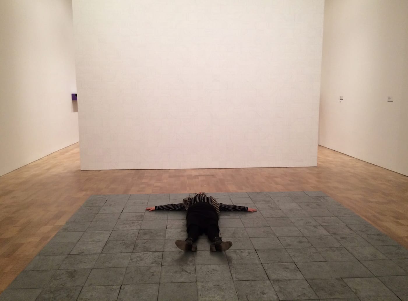 The writer lying on Carl Andre’s “144 Pieces of Zinc” (1967)