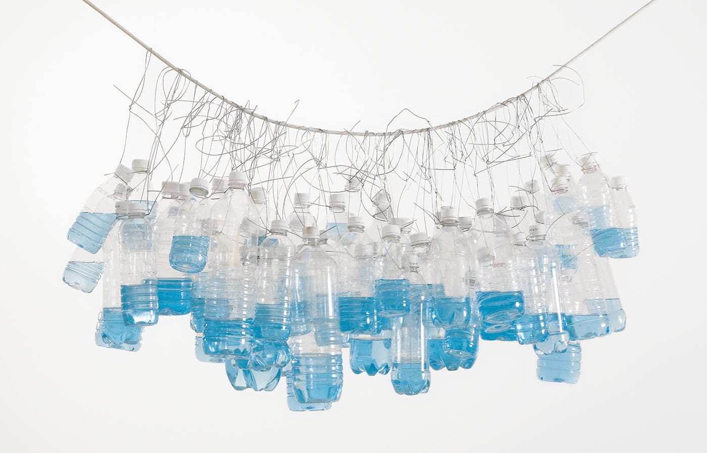 Tony Feher, "It Seemed a Beautiful Day" (2002), plastic bottles with plastic caps, water, food dye, wire, rope (photo by Adam Reich)