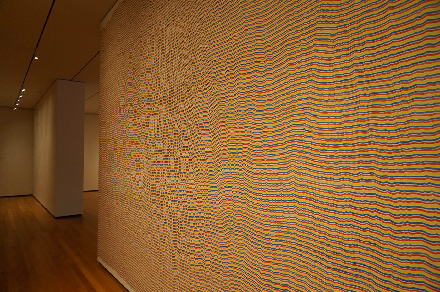 Sol LeWitt, "Wall Drawing #797: The first drafter has a black marker and makes an irregular horizontal line near the top of the wall. Then the second drafter tries to copy it (without touching it) using a red marker. The third drafter does the same, using a yellow marker. The fourth drafter does the same using a blue marker. Then the second drafter followed by the third and fourth copies the last line drawn until the bottom of the wall is reached" (1995), black, red, yellow, blue marker on wall