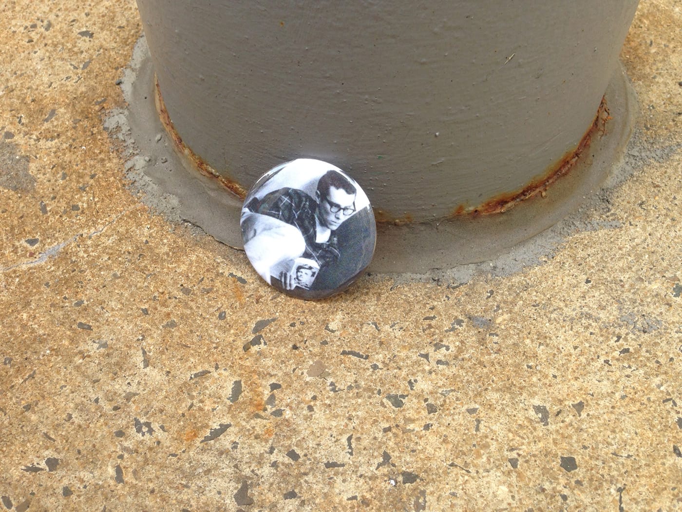 A pin with a photo of a young man — Bernie Sanders? — sitting against a wall reading Arthur Rimbaud (click to enlarge)