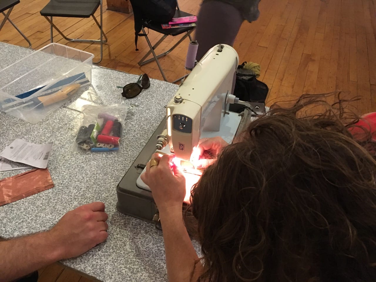 A SPACES visitor making a signal-blocking cell-phone pouch under the guidance of artist Tim Schwartz (click to enlarge)