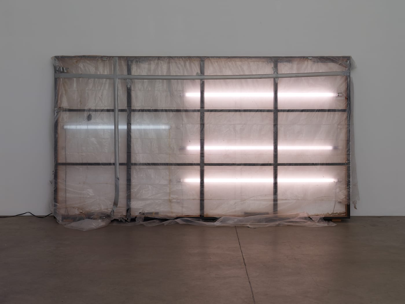 A.L. Steiner, "Eat/Memorial for Maria" (2000–16), wood, paint, low-pressure mercury vapor fluorescent bulbs, hardware, low-density polyethylene sheets, tape, 70 x 128 x 6 in