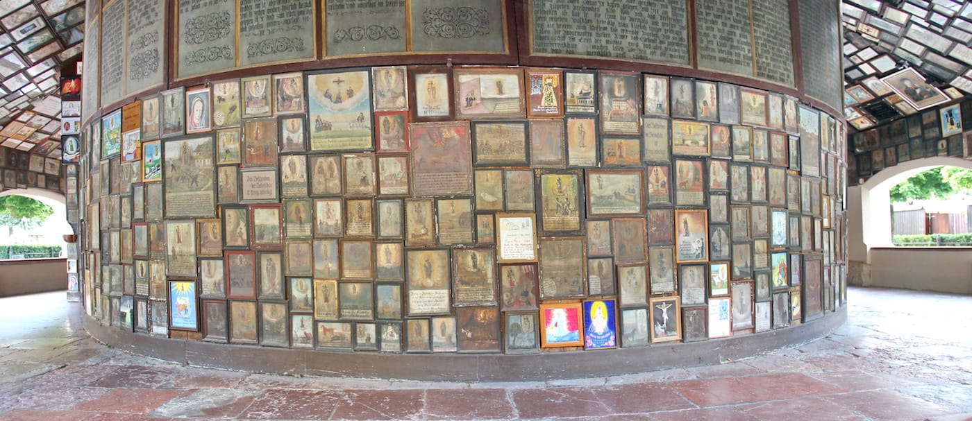 Votive paintings and offerrings on the walls at the back of the chapel at Gnadenkapelle, Altötting, Bavaria, Germany (photo by Mattana/Wikimedia)