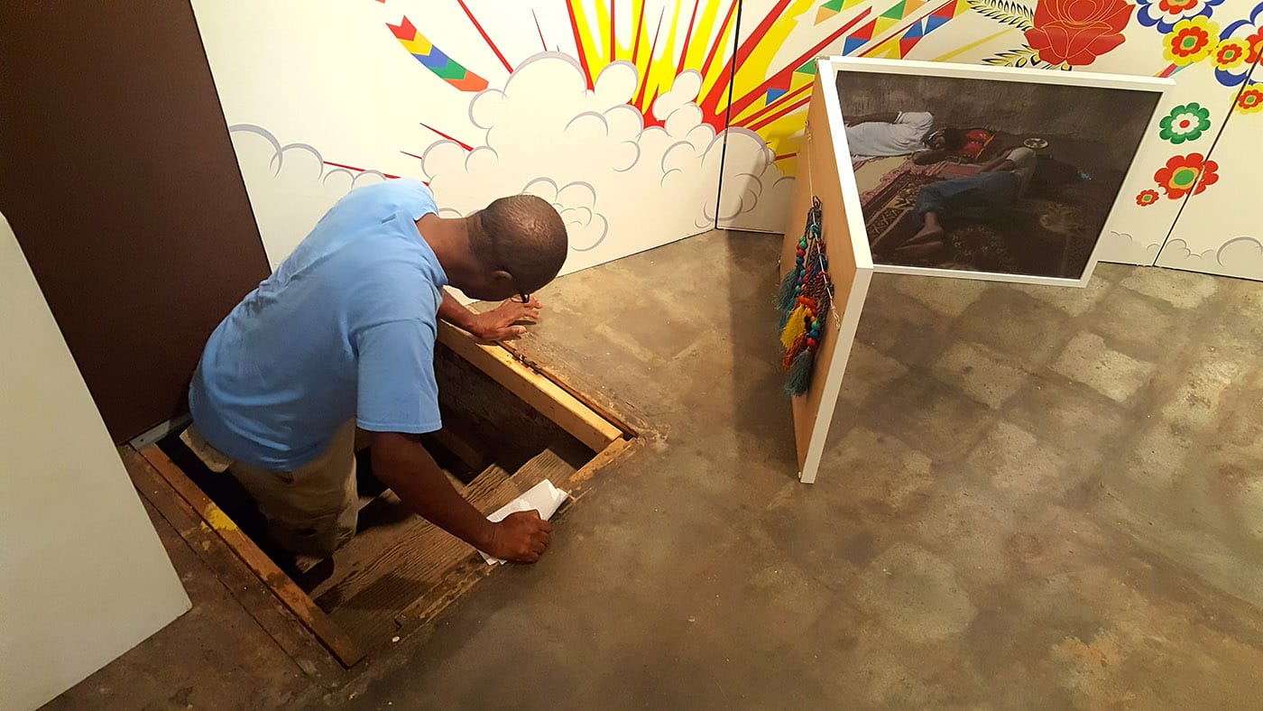 A gallery visitor climbs through the trap door into Khan's inner psyche.
