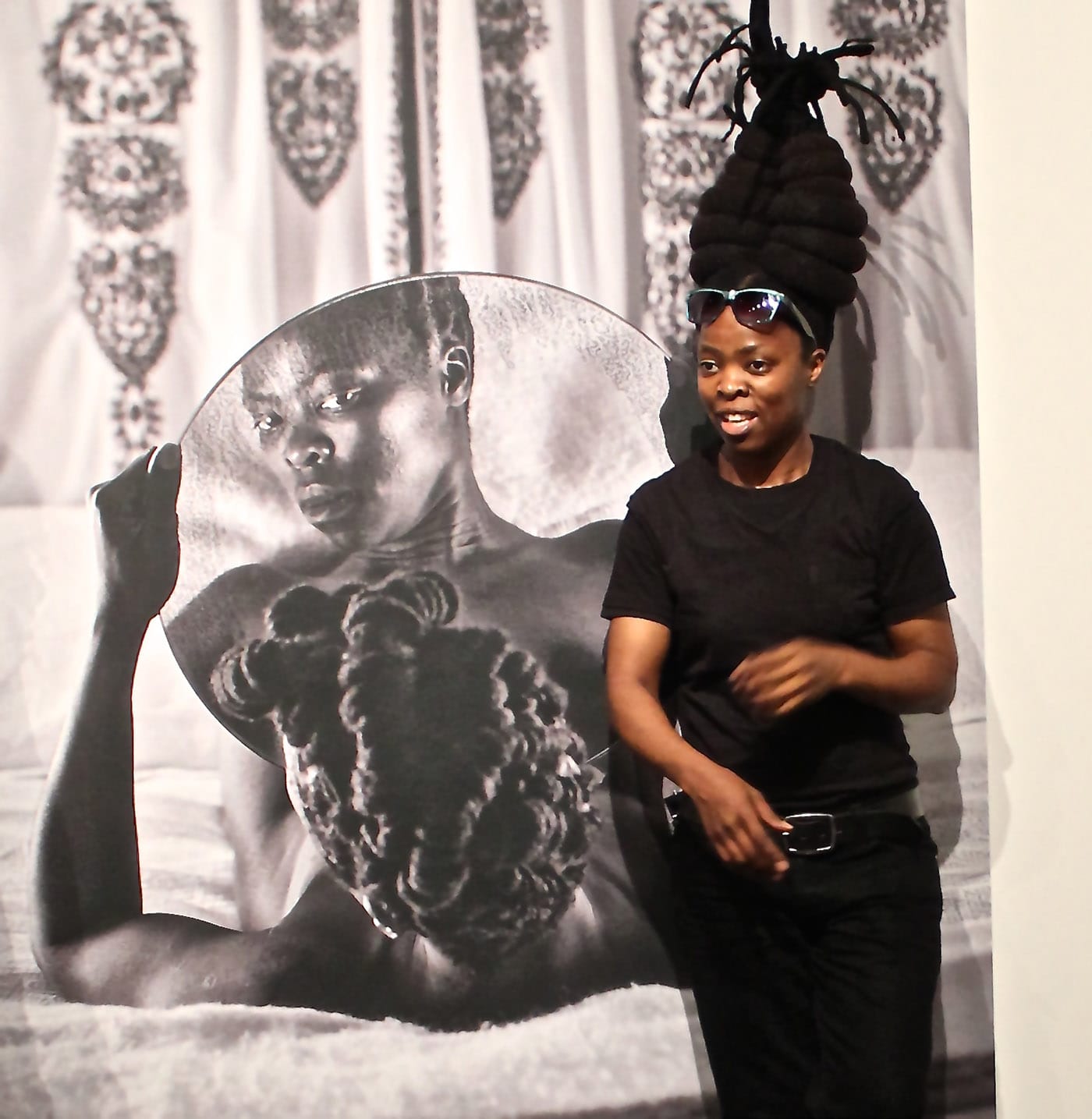 Zanele Muholi poses alongside one of her self-portraits at the Freedom Center.