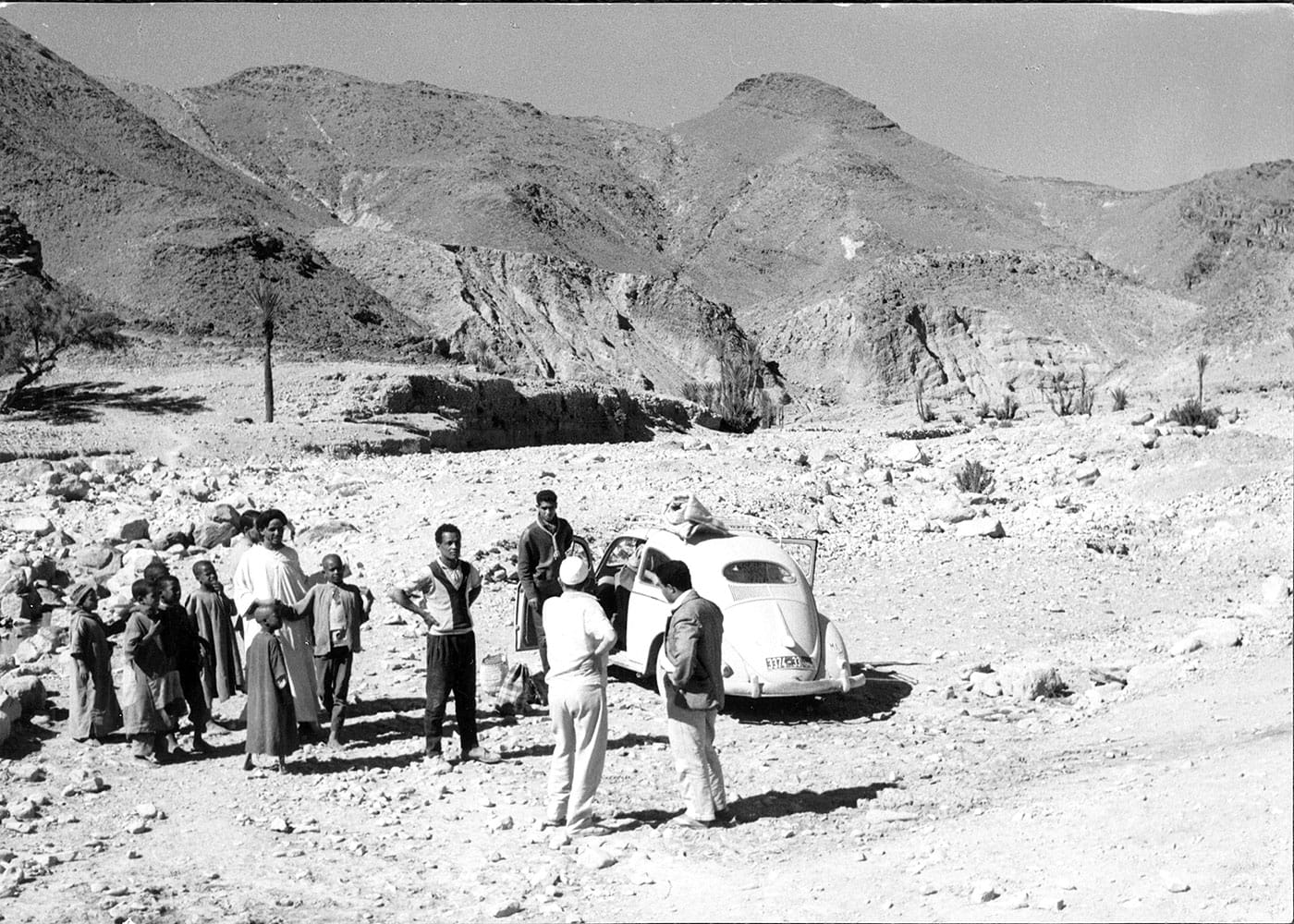 Paul Bowles's VW bug along a Morocco mountain road, with a small group (image courtesy Dust-to-Digital / Library of Congress)