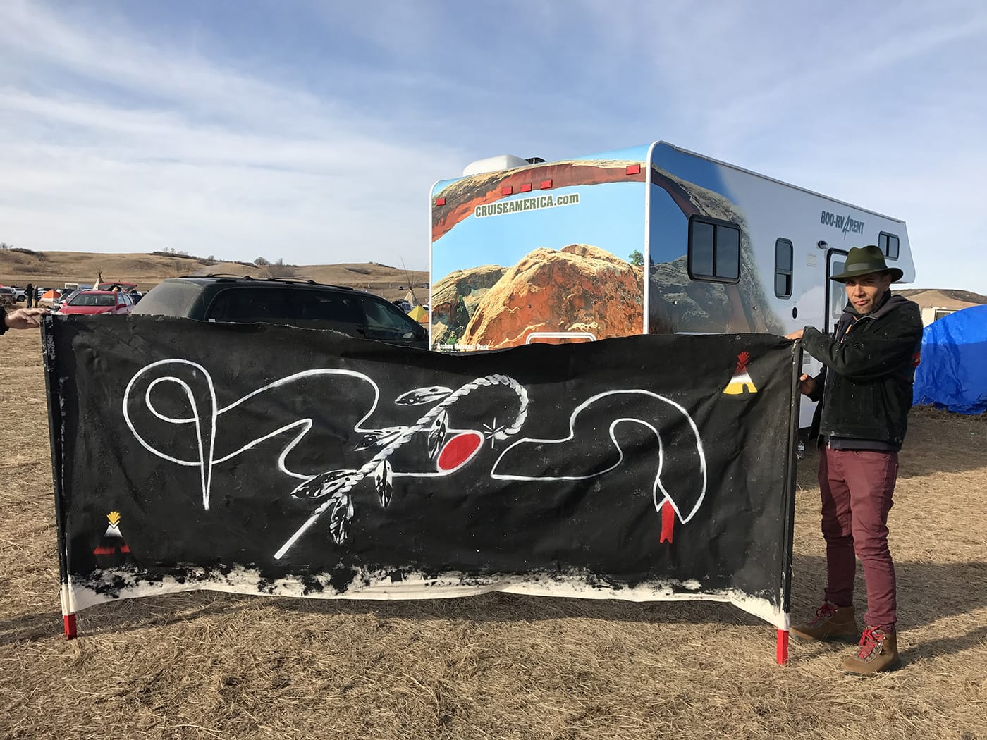 Artist Yatika River with a banner he made for Standing Rock