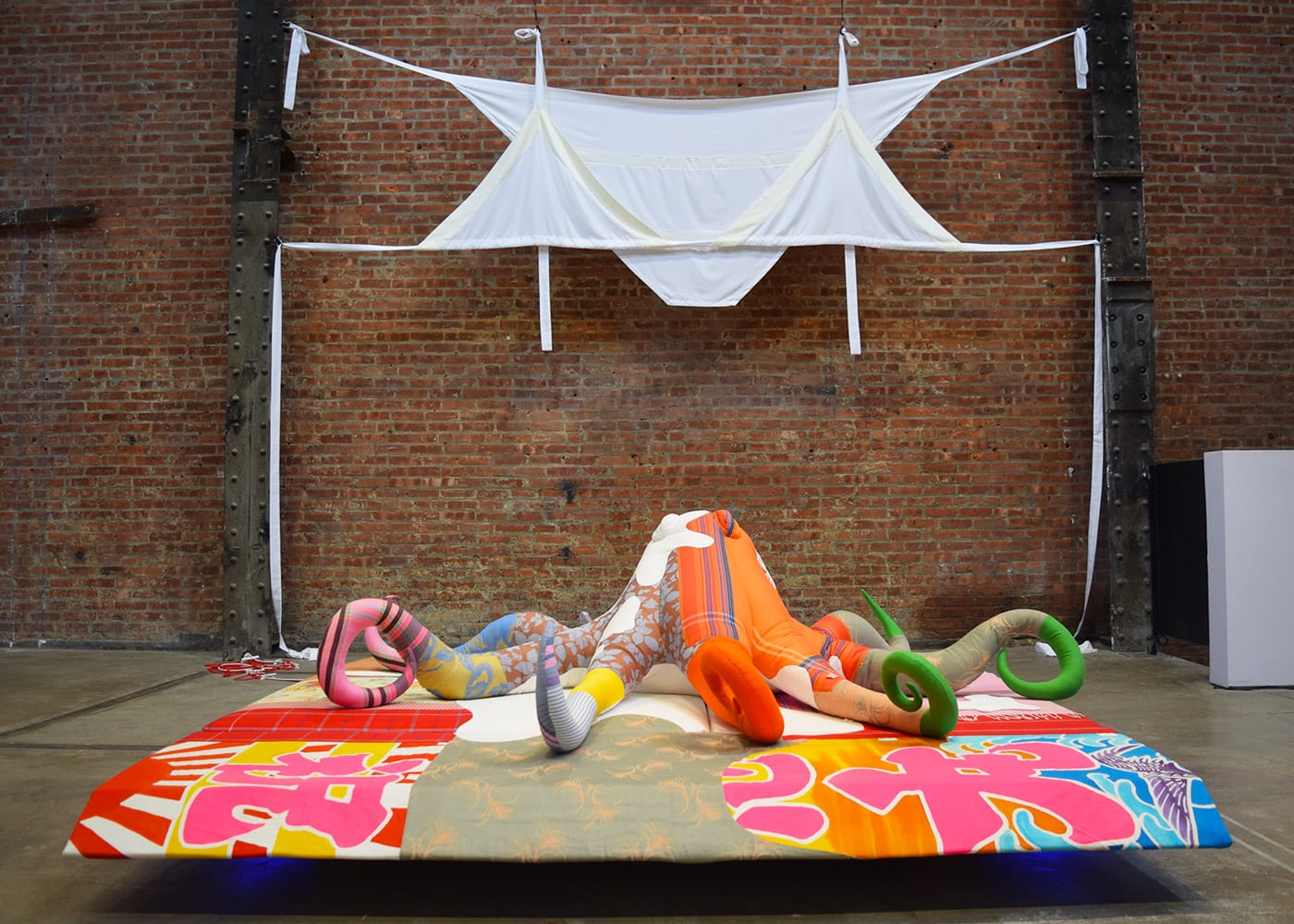 Installation view of <em>Cosima von Bonin: Who's Exploiting Who in the Deep Sea?</em> at SculptureCenter, with "BIKINI II (GHOST VERSION)" (2011) in the background and "TOTAL PRODUCE (MORALITY)" (2010) in the foreground (all photos by the author for Hyperallergic)