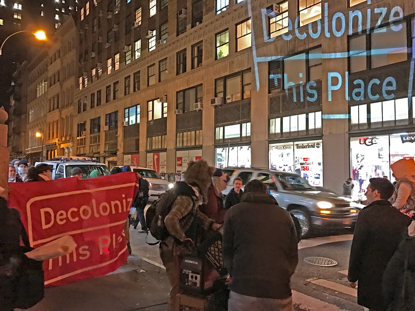 Members of The Illuminator projecting on a building on Walker Street as the march begins.