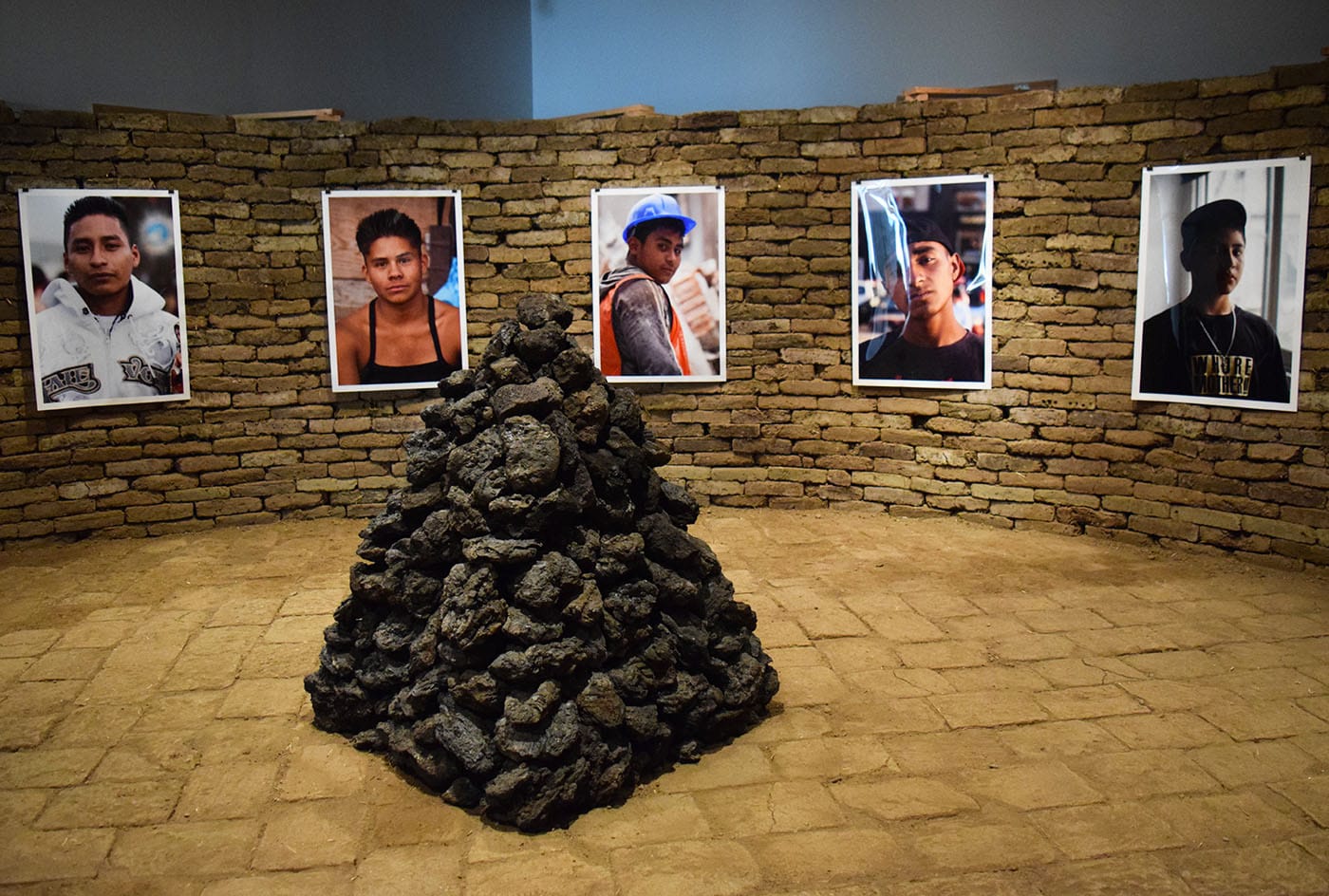 Installation view of Rafa Esparaza's adobe brick installation "Figure Ground: Beyond the White Field" (2017), with stone sculptures by Beatriz Cortez and photos by Dorian Ulises López Marcias