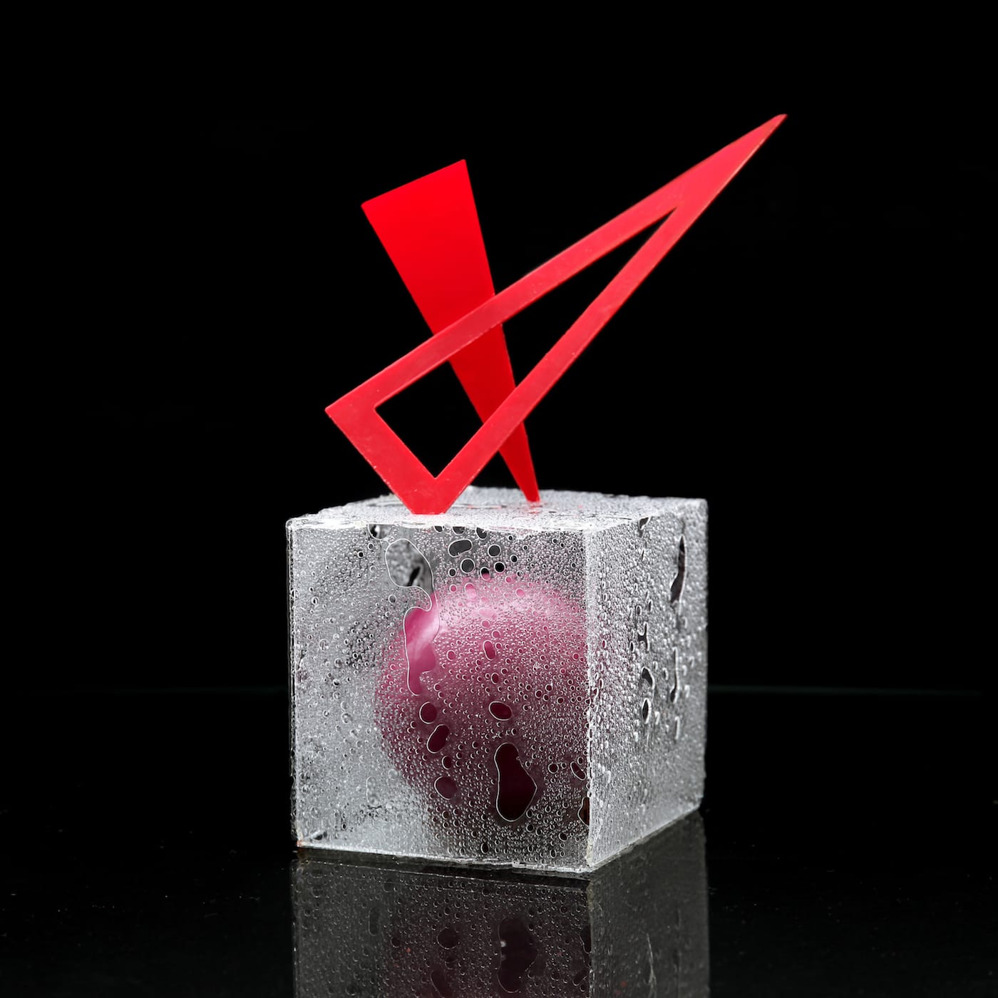 Ball, cube, triangle composition with mousse with caramelized white chocolate, blueberry confit, blackcurrant confit, chocolate sponge cake with red currant, berry glaze, and, for decoration, isomalt and chocolate, by Dinara Kasko