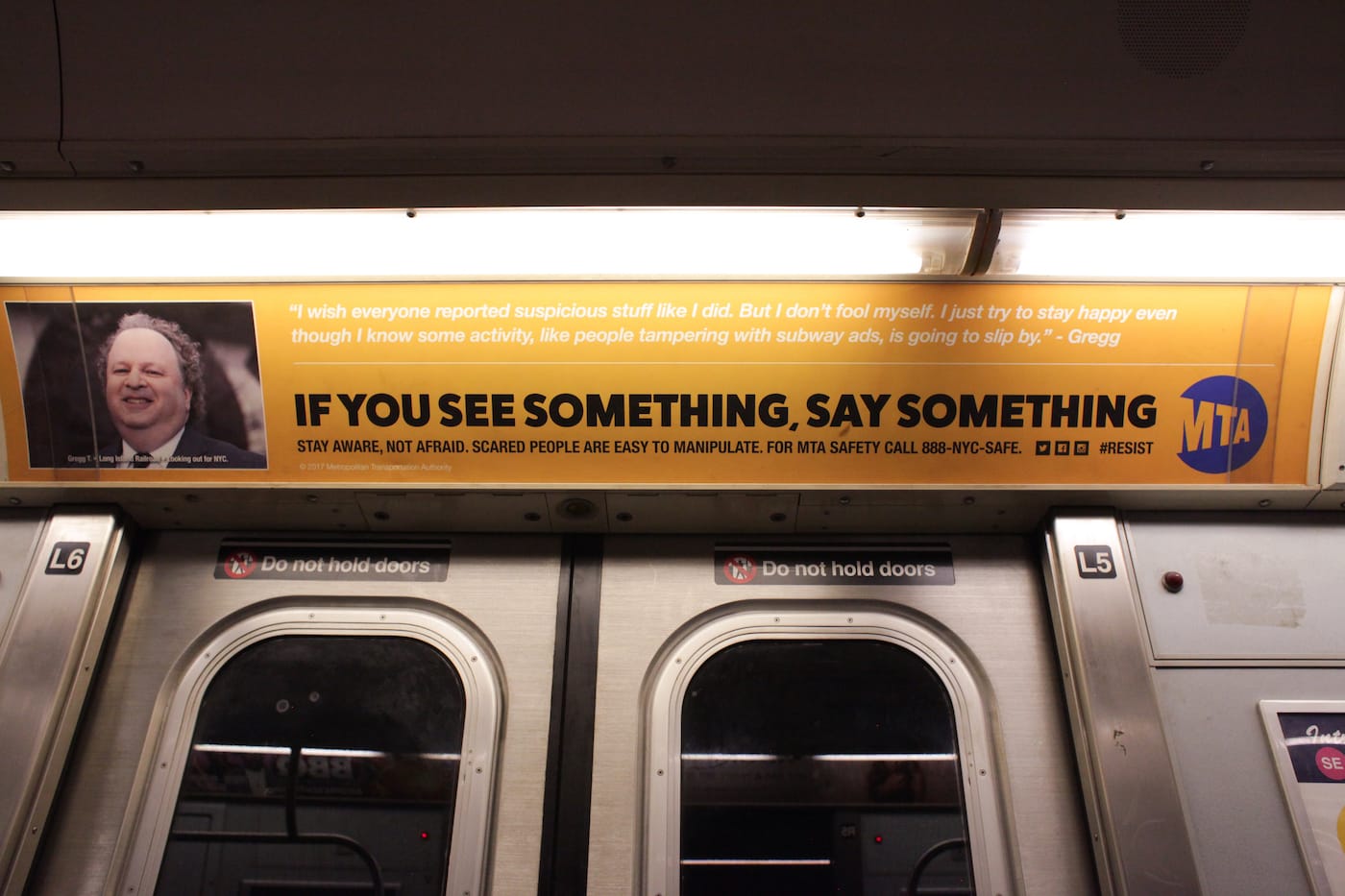 One of the substitute MTA ads, which reads: "I wish everyone reported suspicious packages like I did. I just try to stay happy even though I know some activity, like people tampering with subway ads, is going to slip by."