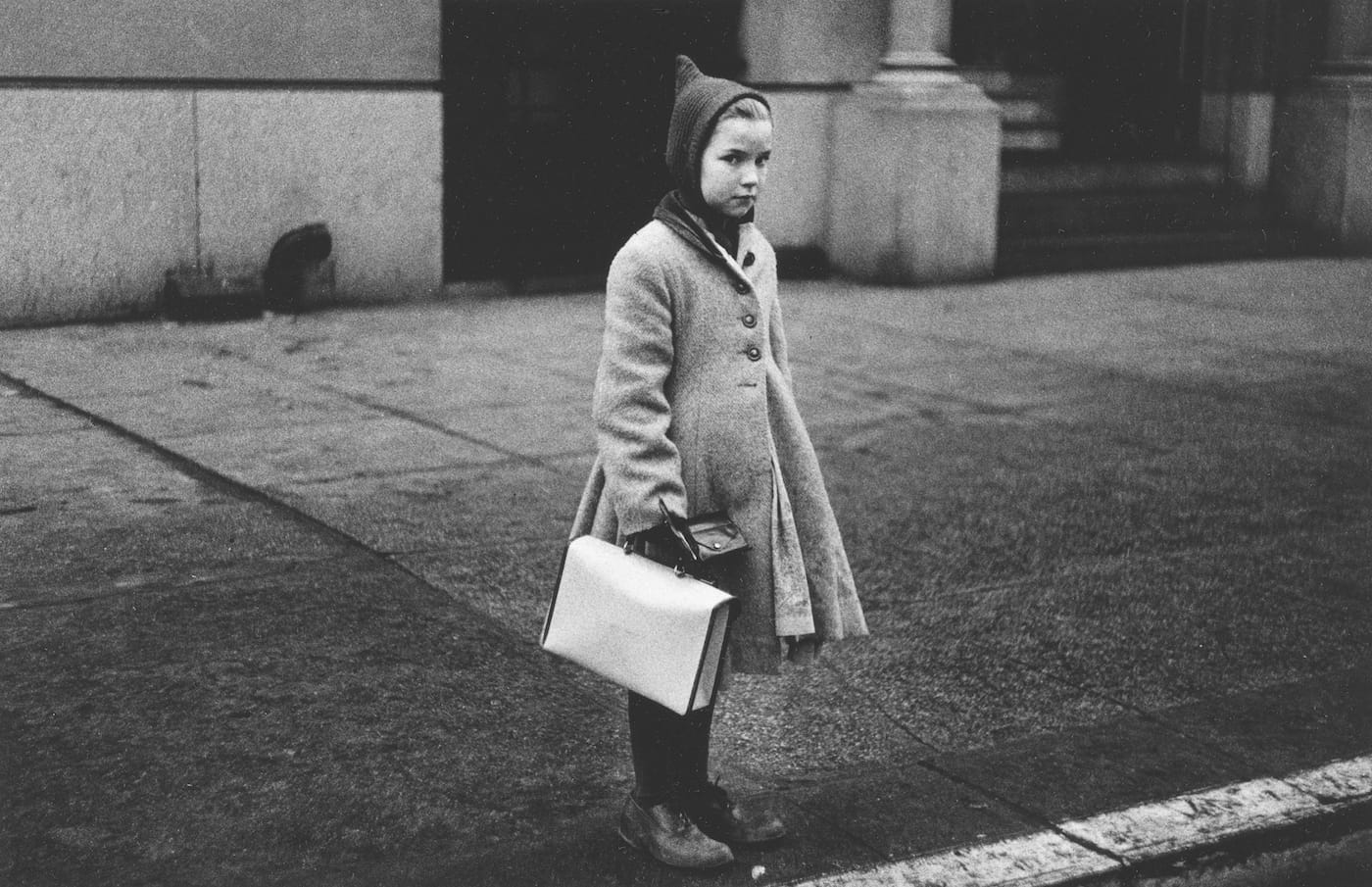 Diane Arbus, "Girl with a pointy hood and white schoolbag at the curb, N.Y.C." (1957) (courtesy The Metropolitan Museum of Art, New York; copyright © The Estate of Diane Arbus, LLC; all rights reserved)