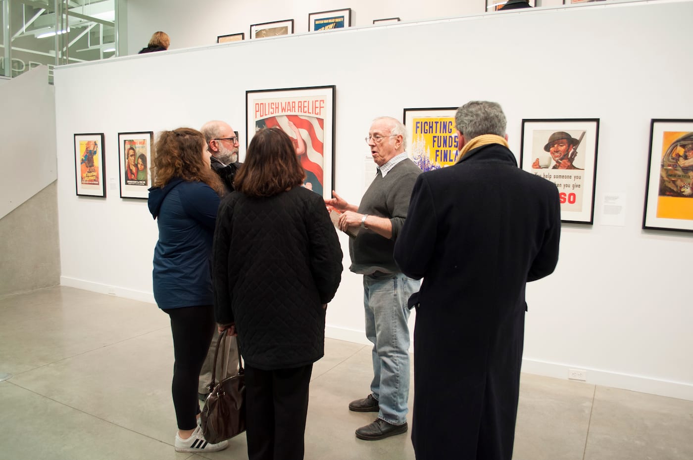 Collector Hal Wert talk with visitors about the exhibition <em>Work, Fight, Give: American Relief Posters of WWII</em> in February 2017 at Mid-America Arts Alliance. (photo courtesy Mid-America Arts Alliance)