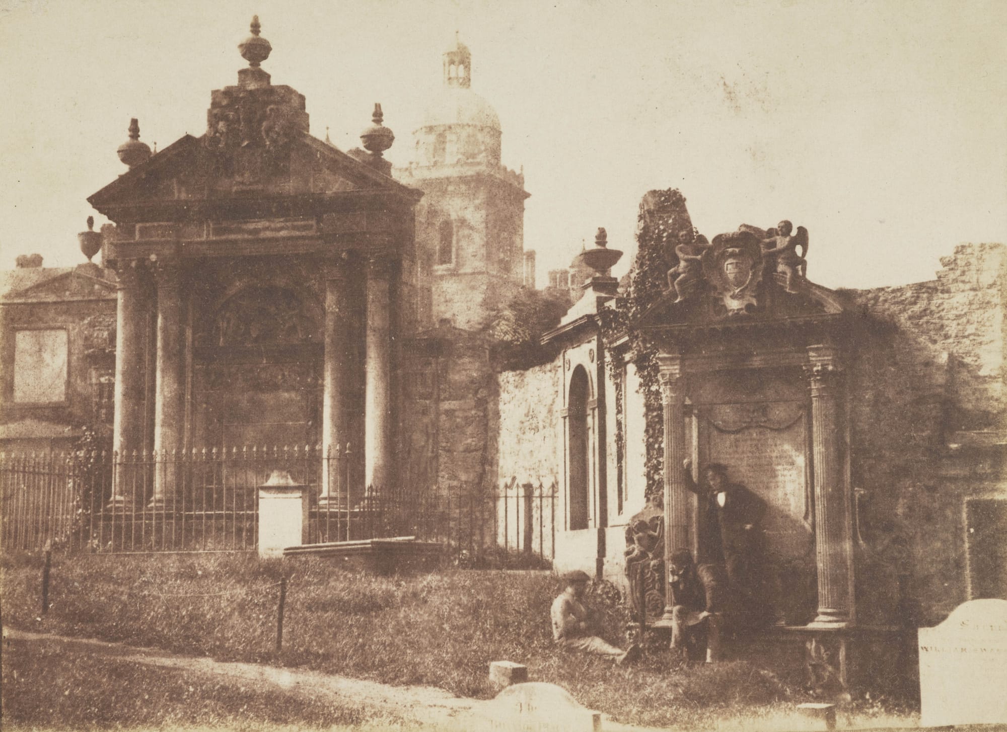 David Octavius Hill and Robert Adamson, "Greyfriar's Churchyard, a group of monuments including the Paton and Chalmers monuments, with Heriot's Hospital in the background and David Octavius Hill seated on the monument" (1843-47), calotype print (courtesy Scottish National Portrait Gallery)
