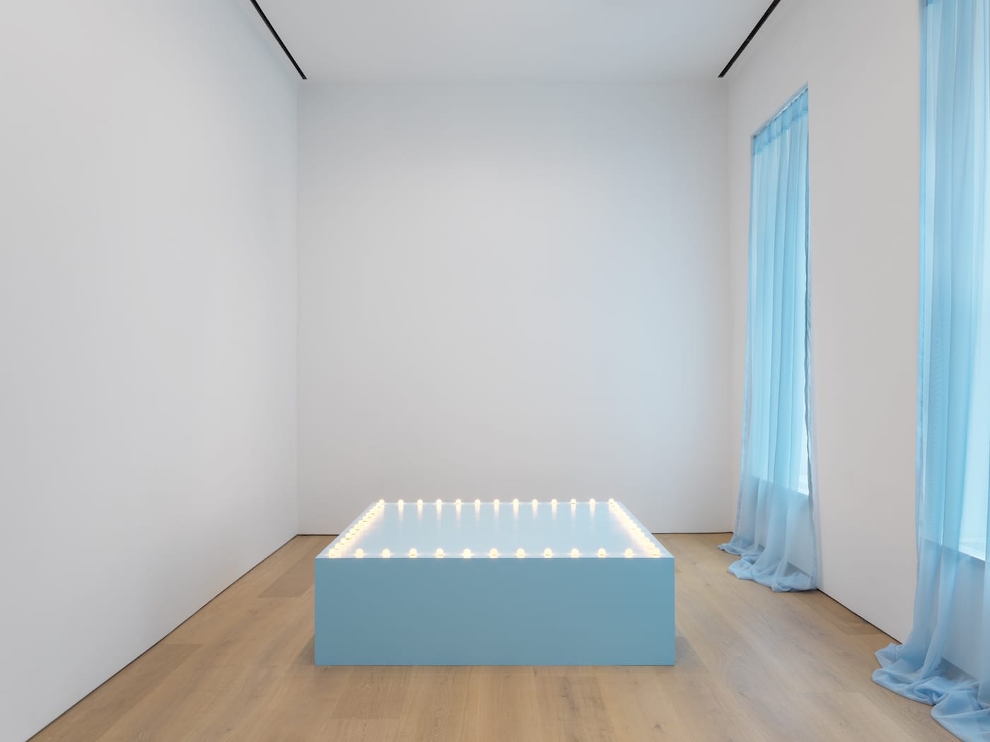Felix Gonzalez-Torres, "Untitled" (Go-Go Dancing Platform) (1991), wood, light bulbs, acrylic paint, and Go-Go dancer in silver lamé bikini, sneakers, and personal listening device; overall dimensions vary with installation; platform: 21 1/2 x 72 x 72 in (Kunstmuseum St. Gallen, on permanent loan from a private collection; © The Felix Gonzalez-Torres Foundation)