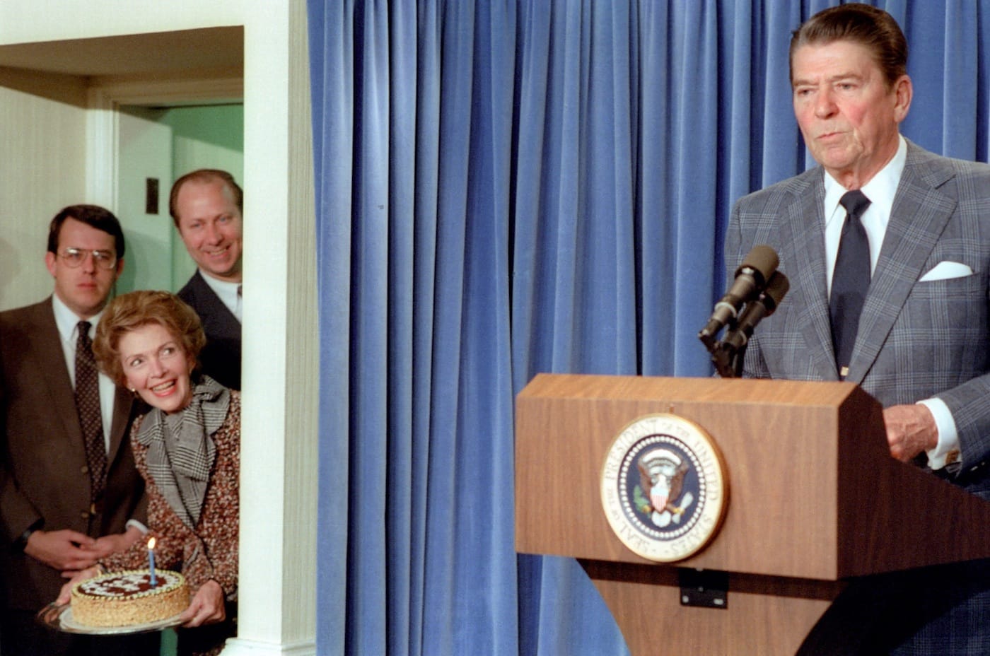 Nancy Reagan surprises President Ronald Reagan with a birthday cake during a White House press briefing (1983), as seen in The Reagan Show, directed by Pacho Velez and Sierra Pettengill. (photo courtesy of the Ronald Reagan Presidential Library; Gravitas Ventures and CNN Films)