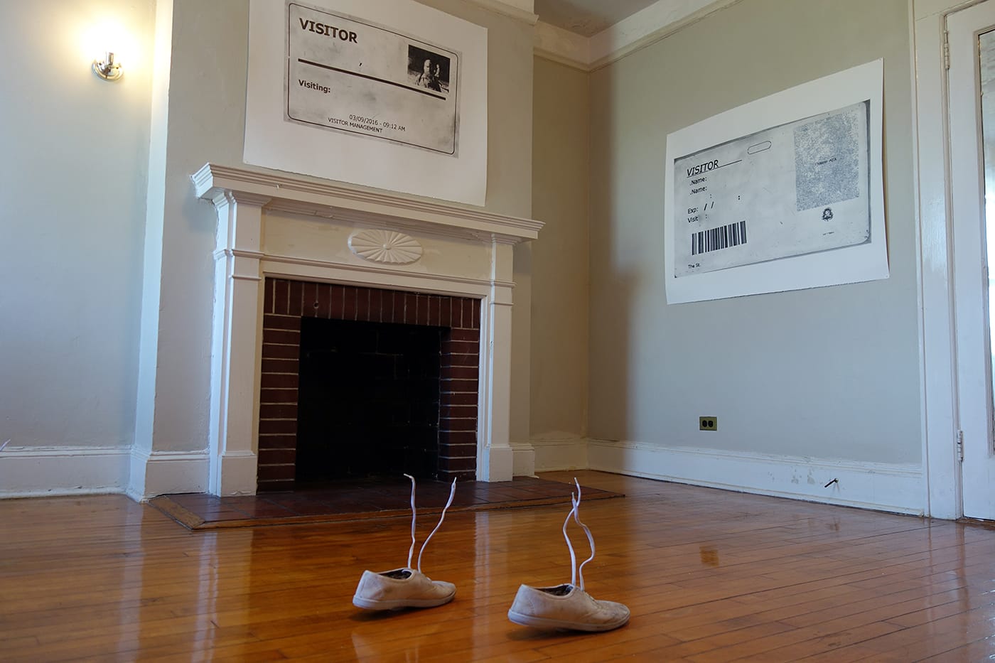 Installation view of work by Eliot Greenwald's "Visitor," with self-portraits made with powdered graphite based on security badges the artist received while working as an art handler in NYC