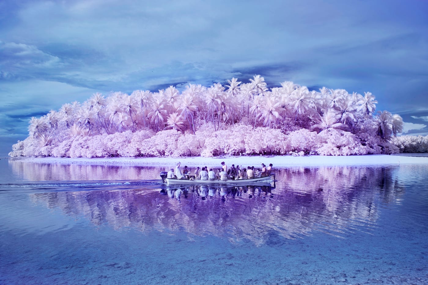 Sanne de Wilde, "On the way back from a picnic to one of the uninhabited small islands around Pingelap with the colorblind Pingelapese and all the children of the one school of the island. The bay is now protected, islanders are no longer allowed to fish for turtles. Because of the infrared colors the scene looks very romantic, at the same time there’s the visual connotation of the boats full of refugees setting off for a better future." (© Sanne de Wilde)