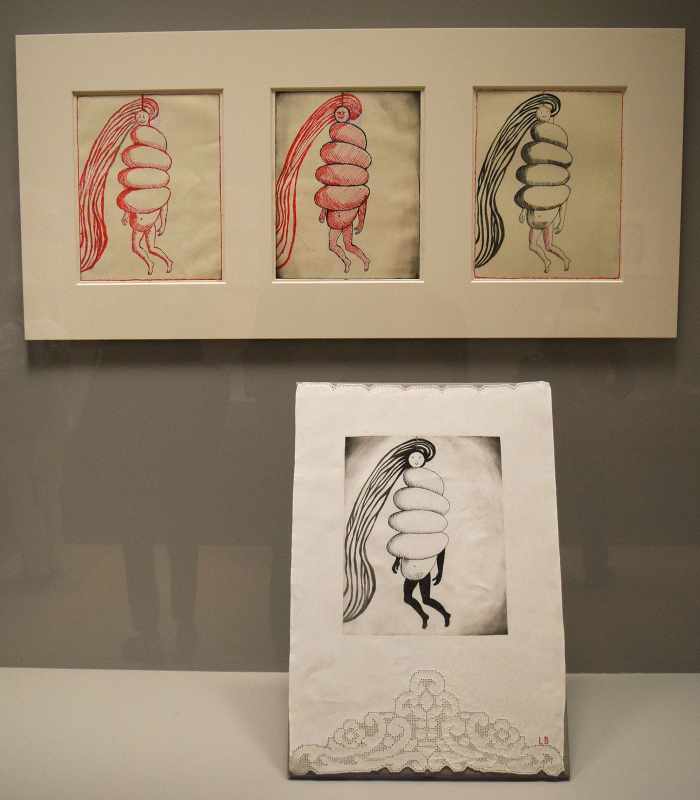 Louise Bourgeois, "Spiral Woman" (2002), drypoint and engraving with selective wiping on fabric in the foreground; above, "Spiral Woman" (2001), drypoint with ink, pencil, and gouache at left and center, drypoint, engraving, and aquatint at right
