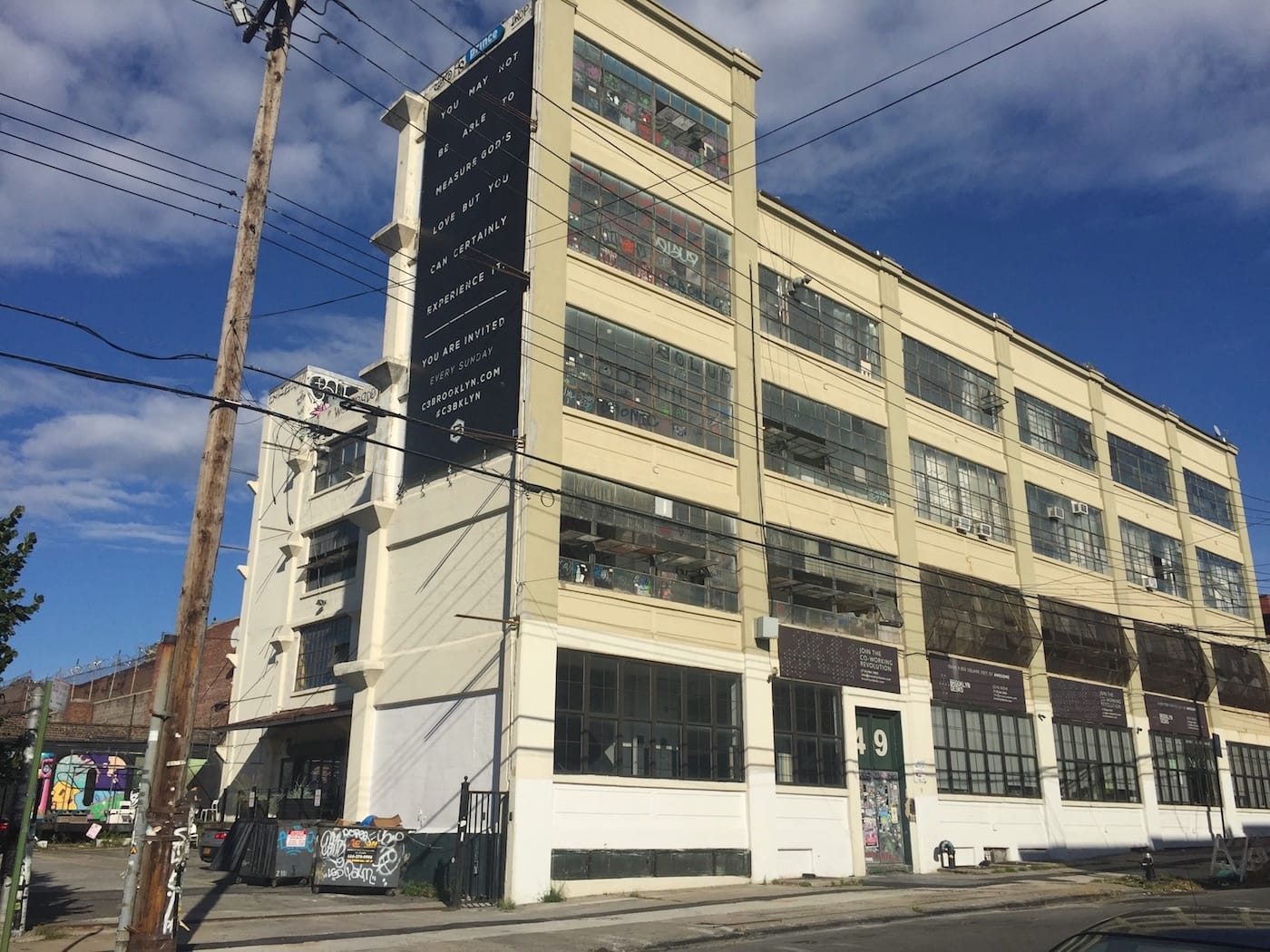 A building on Wyckoff Avenue advertising "over 9,000 square feet of awesome." (photo by the author for Hyperallergic)