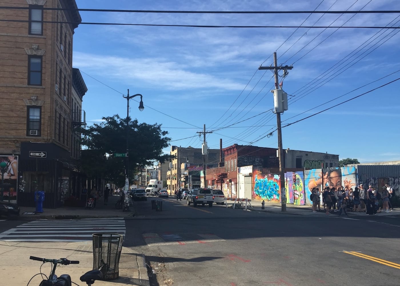 Wyckoff Avenue in Bushwick, with a tour group at right (photo by the author for Hyperallergic)