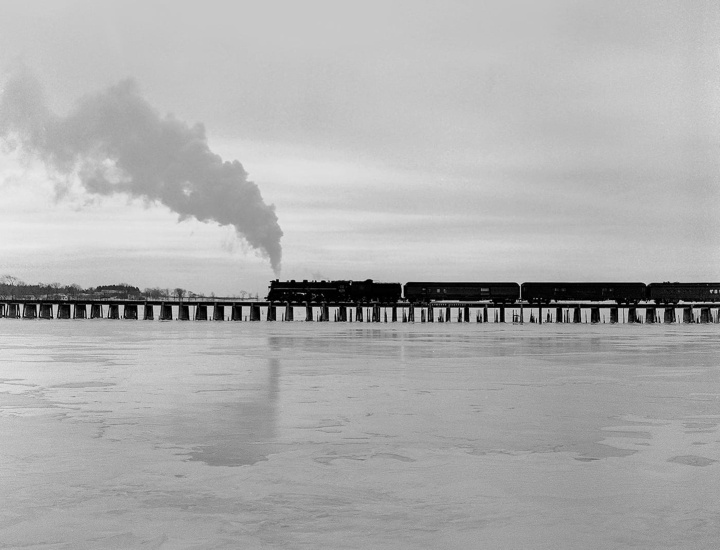 Jim Shaughnessy, "Central Vermont’s Ambassador passenger train crosses trestle over Missisquoi Bay, Lake Champlain, Vermont" (1954) (courtesy the artist and Thames & Hudson)