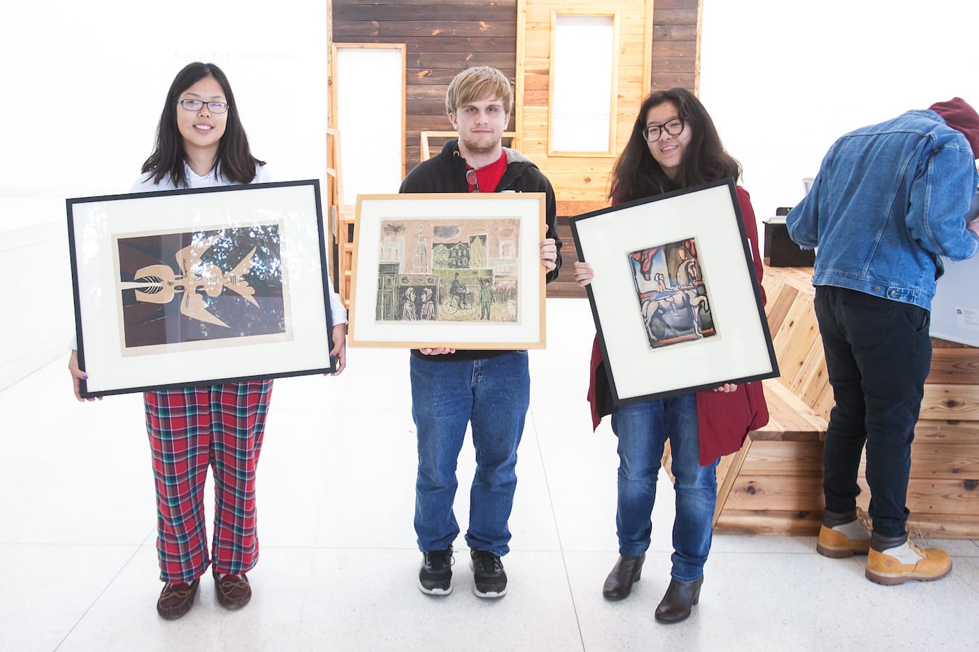 From left students, Christine Gu, Nick Sitaras and Susie Xu hold their chosen pieces of art in the Smart Museum on Sunday, October 1, 2017 (photo by Eddie Quinones, courtesy the University of Chicago)