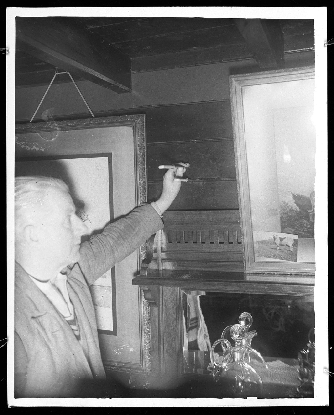 "The slit in the matchboarding through which Gef threw a packing-case needle at Capt. Dennis. The depth of the slit (4") is shown by the other knife which Mr. Irving holds.," from <em>Gef!: The Strange Tale of an Extra-special Talking Mongoose</em> (courtesy Strange Attractor)