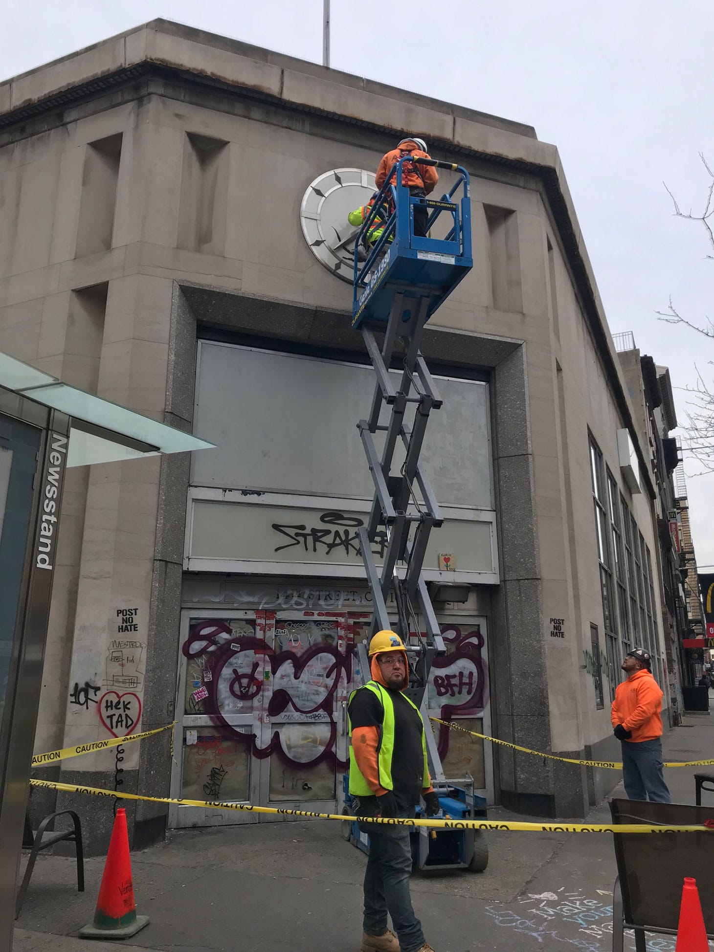 Workers taking down the Banksy at 14th Street and Sixth Avenue in Manhattan (photo by Melissa Stern for Hyperallergic)