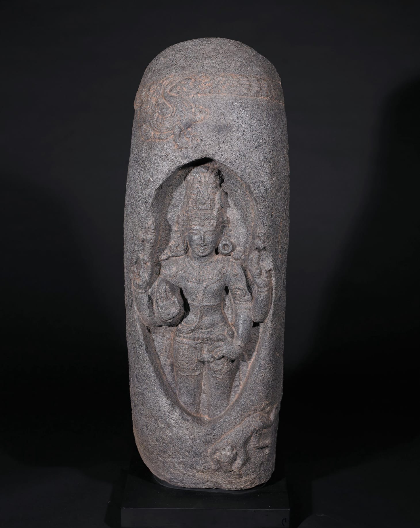 "Lingodhbhavamurti (Shiva Manifesting within the Linga of Flames)" (Chola dynasty, c. 1150), origin: Tamil Nadu, South India, a large linga-shaped carving that is splitting open to reveal Shiva inside, Brahma (Goose) and Vishnu (Boar) are posed above and below, granite, 45 x 16 x 12 in. (image courtesy Birmingham Museum of Art)