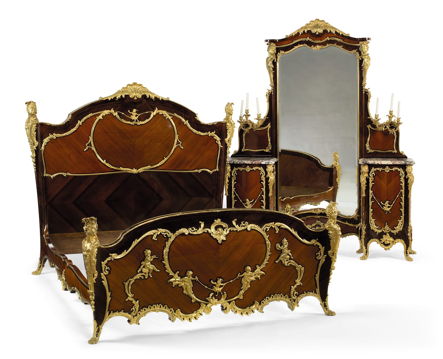 A fine and large French ormolu-mounted kingwood and bois satiné three-piece bedroom suite in the manner of Charles Cressent, by Emmanuel Zwierner, Paris (late 19th century), comprising a bed, a commode, and a large vanity and mirror, the commode: 38 inches high, 62 ½ inches wide, 26 ½ inches deep, the bed: 66 ½ inches high, 77 ½ inches wide, 85 ½ inches deep, the vanity: 92 ½ inches high, 72 ¾ inches wide, 18 inches deep (image courtesy Christie's)