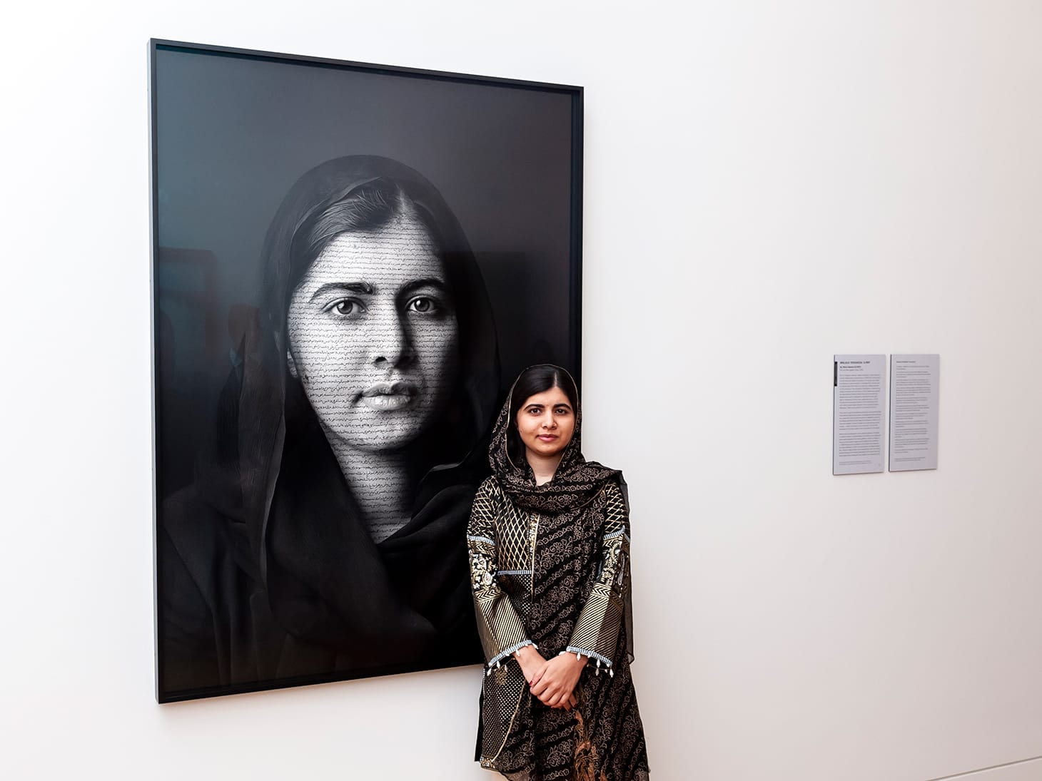 Malala Yousafzai with her portrait "Malala Yousafzai" by Shirin Neshat (2018) at the National Portrait Gallery, London (photo by Jorge Herrera, image courtesy the National Portrait Gallery, London)