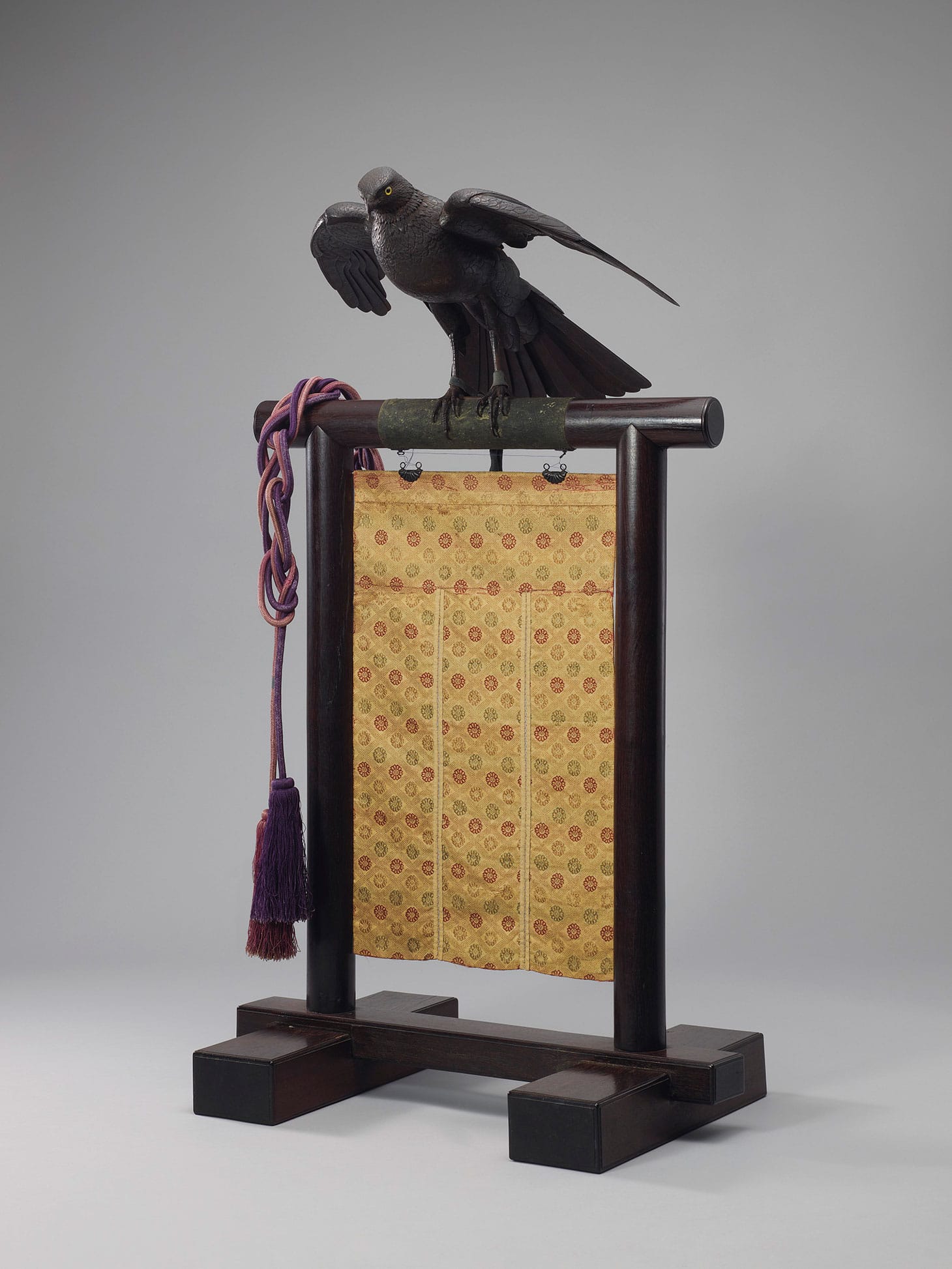 An important iron articulated sculpture of an eagle on stand, Meiji period (c. 1894), 19 3/8 inches long without stand, with original wood box, stand, and brocade curtain (image courtesy Christie's)