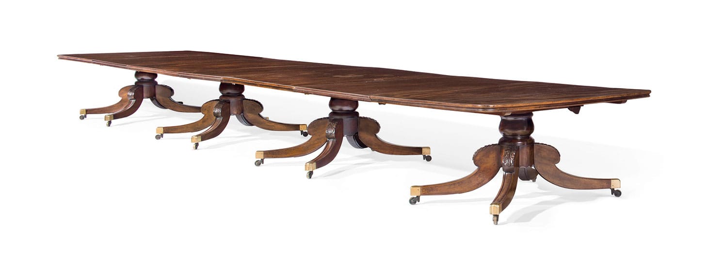 An Irish William IV mahogany four-pedestal extension dining table by Williams and Gibton (c. 1835), with rounded rectangular end-sections above four acanthus-carved baluster shafts with splayed quadripartite bases, two pedestals stamped Williams & Gibton 22823, with three additional leaves, 29 inches high, 60 inches wide, 324 inches long (fully extended) (image courtesy Christie's)