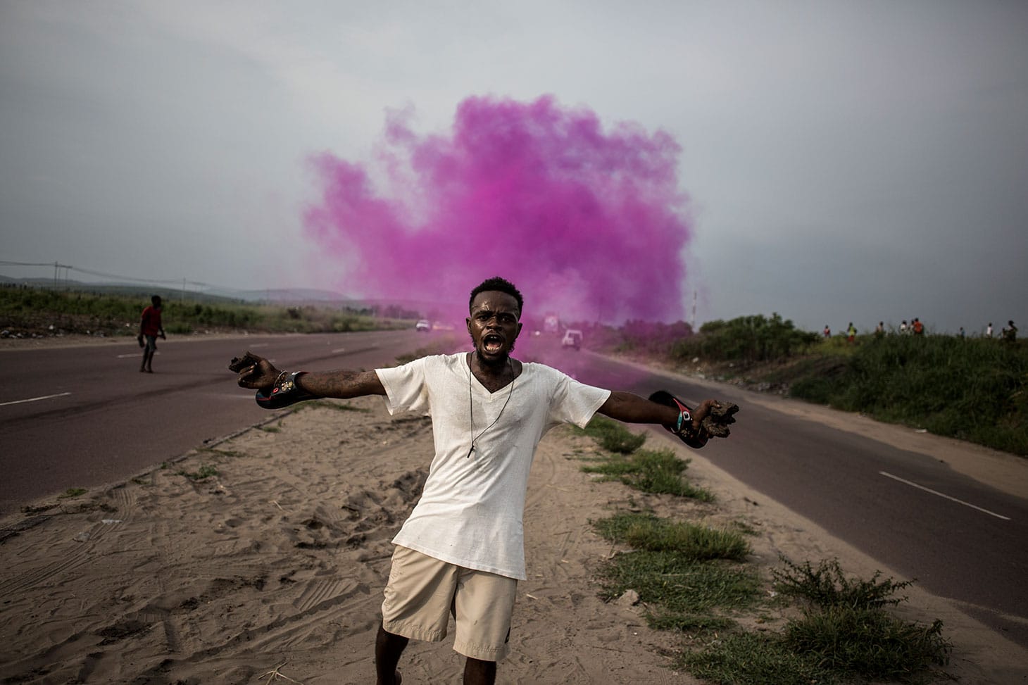 John Wessels, "A Fight for Democracy" (2018): A supporter of Martin Fayulu, leader of an opposition party, runs from police tear gas in Kinshasa, on December 19, 2018 (© John Wessels, Agence France-Presse)