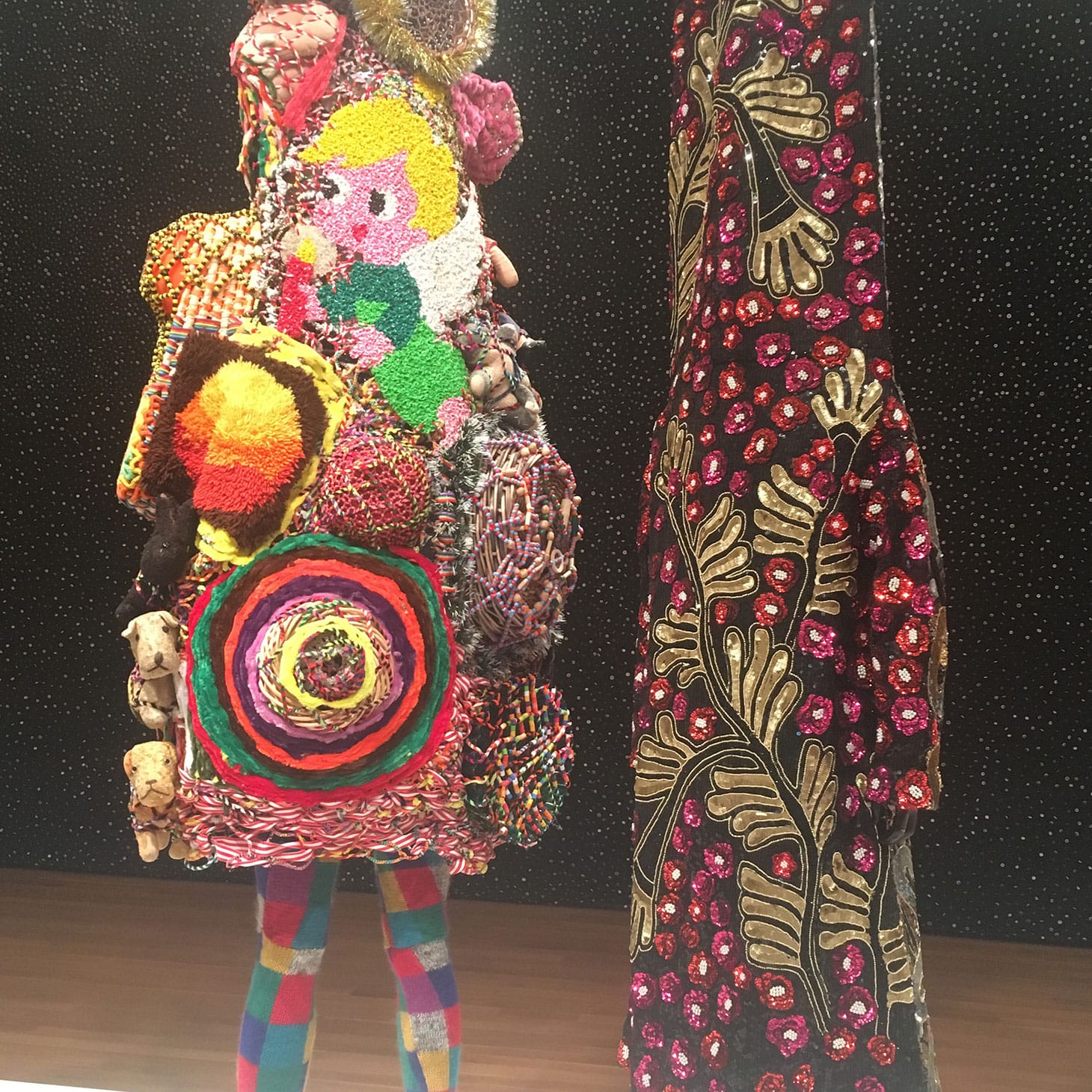 Nick Cave, “Soundsuit” (2011), mixed media, including vintage toys, pipe cleaners, bugle beads, upholstery, metal, and mannequin , 109 x 38 x 31 inches; and “Soundsuit” (2012),  mixed media, including beaded and sequined garments, fabric, metal, and mannequin, 113 x 29 x 26 inches (photo by the author for Hyperallergic)