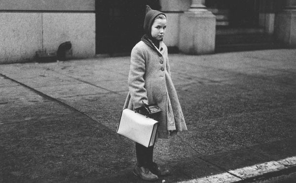 Diane Arbus, "Girl with a pointy hood and white schoolbag at the curb, N.Y.C." (1957) (courtesy The Metropolitan Museum of Ar