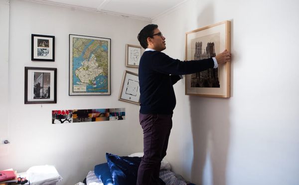 A Williams College student hanging a work on loan from the WALLS program in his dorm room (photo by Julia Sabot, courtesy Wil