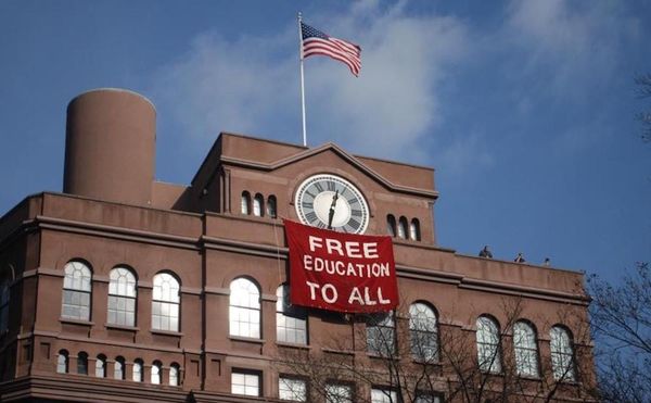 Students hang banner below the historic clock tower of the Cooper Union Foundation Building in December 2012. (photo by Free
