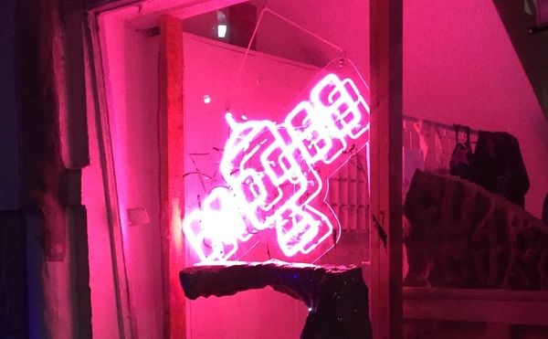A neon sign of the Satellite Art Show logo at the 2017 edition of the fair