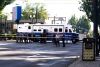Officers gather in front of a Portland Police Bureau mobile command unit parked on Holladay and NE Grand at the scene of an
