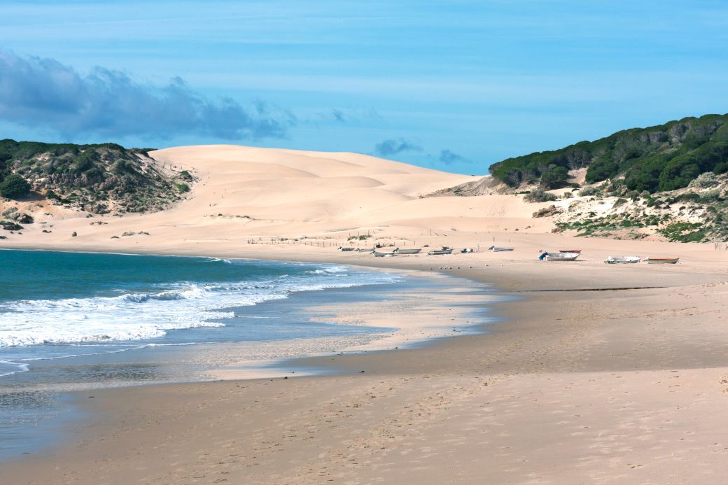 Sand dunes and boats on the sand at Bolonia - best beaches in Spain