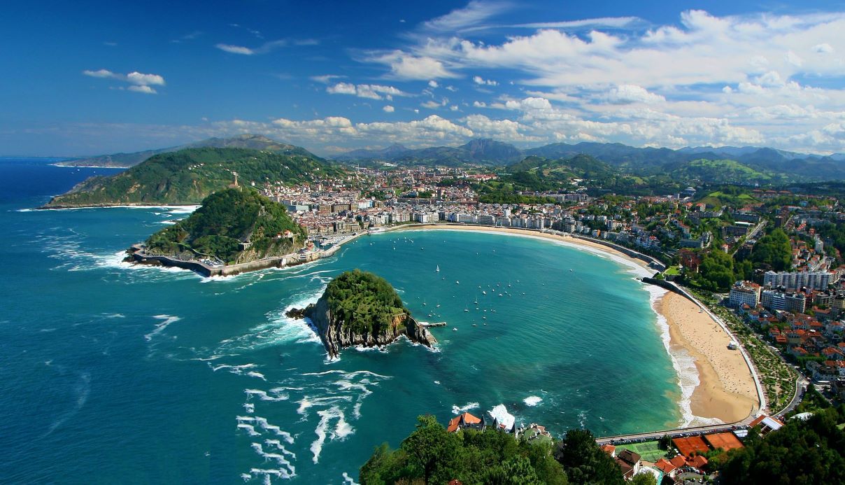 The horseshoe shaped beach at San Sebastian, with an island in the middle of the cove - best beaches in Spain