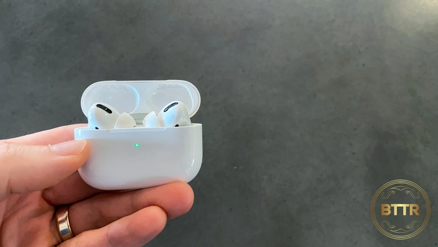 Holding the Airpods case in hand with the earbuds inside