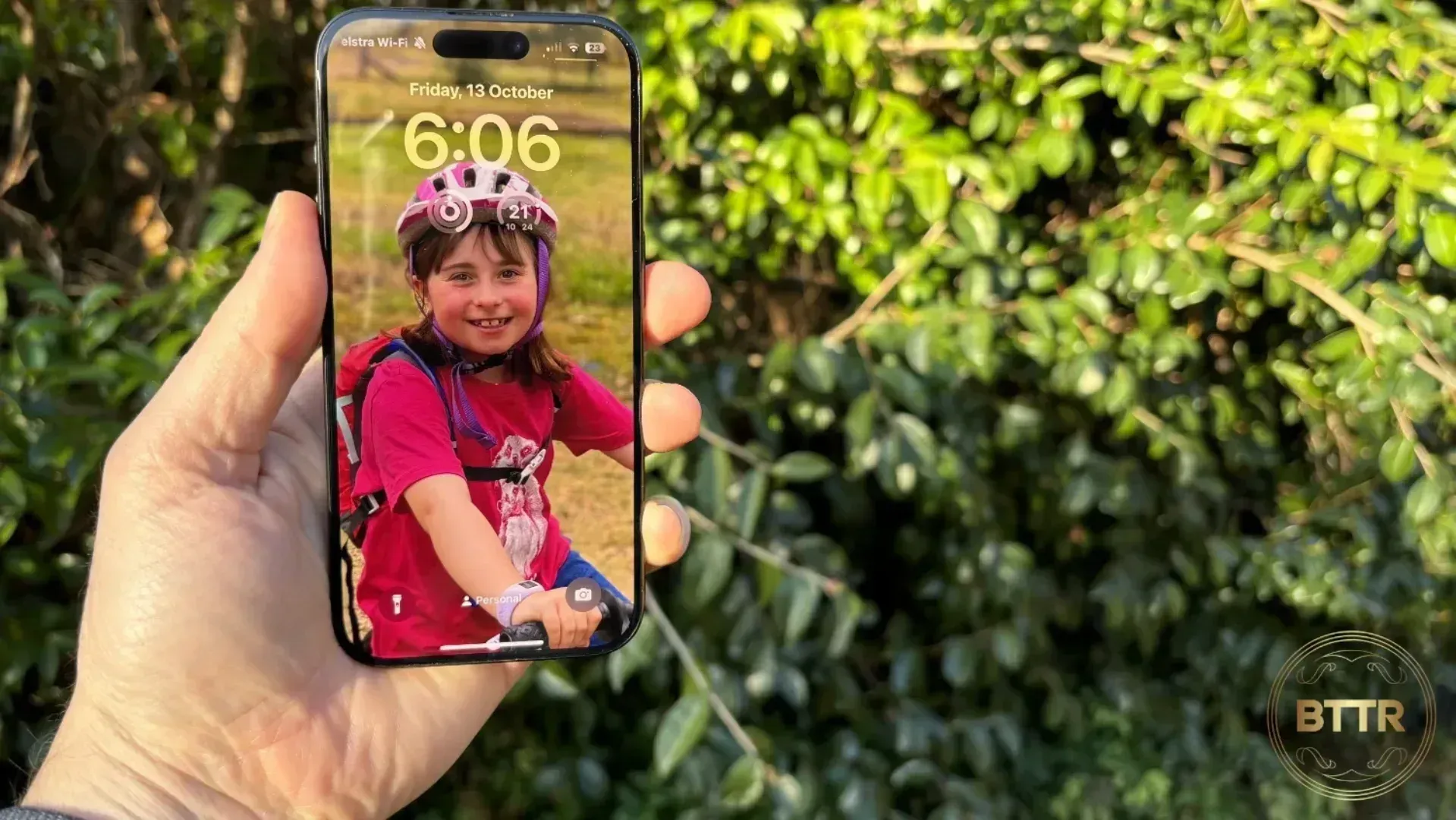 Holding the iPhone 15 Pro in front of trees